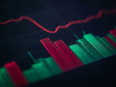 Red line graph above red and green bar columns on a dark trading screen